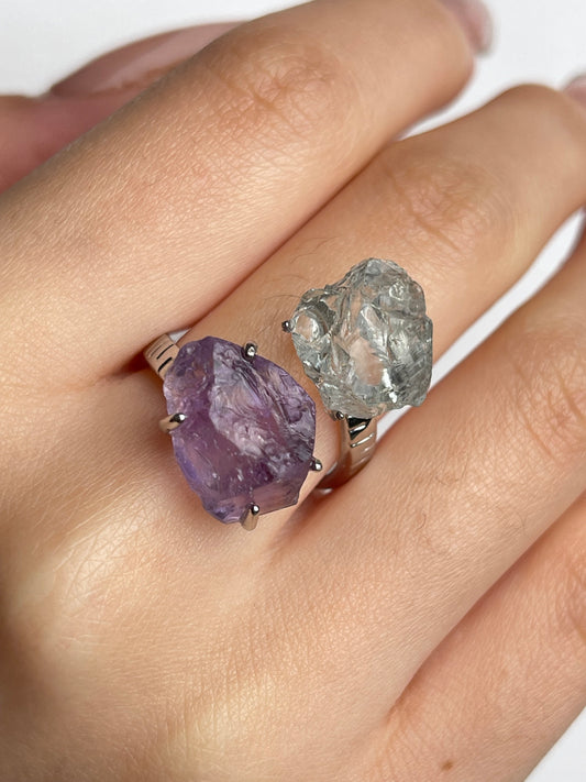 Close up of amethyst and green quartz raw crystal twin ring worn on hand natural unpolished crystals