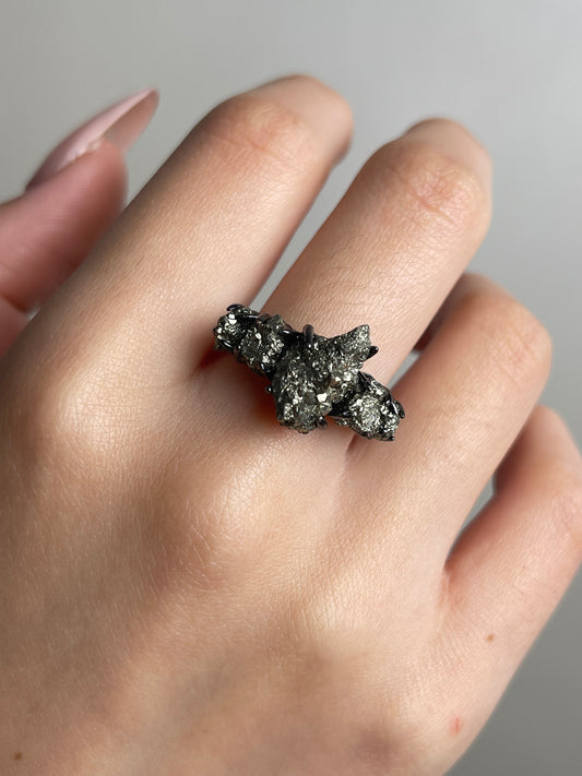 Close up of chalcopyrite raw mineral specimen ring worn on han