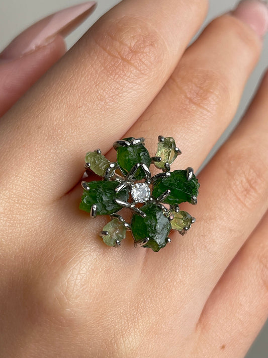 Close-up of Chrome Diopside and Peridot snowflake raw crystal ring worn on hand