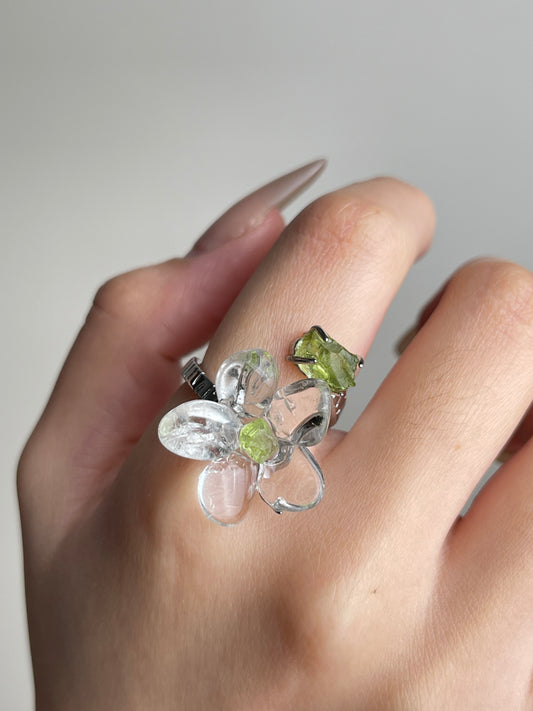 Close-up hand view of Clear Quartz Flower Ring with raw Peridot