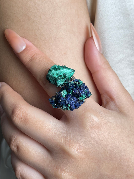 Close-up hand shot of fibrous malachite and azurite mineral specimen ring showing natural fibrous texture and blue mineral base.