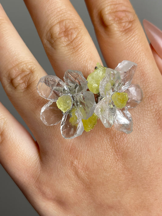 Close-up of quartz and brucite ring showing flower and raw crystal contrast on hand