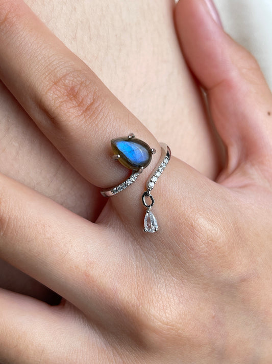 Close-up hand shot of pear cut Labradorite open ring from India showing blue flash and silver-tone band