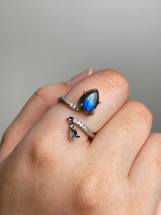 Close-up hand shot of pear cut Labradorite open ring from India showing blue flash and silver-tone band