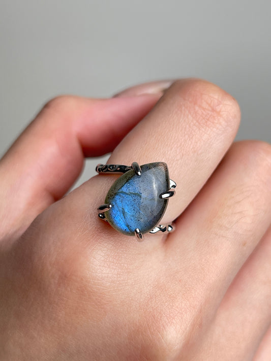 Pear cut Labradorite ring from India shown on hand close up with blue labradorescence