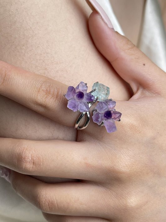 Close up hand wearing raw Amethyst flower and Aquamarine crystal ring