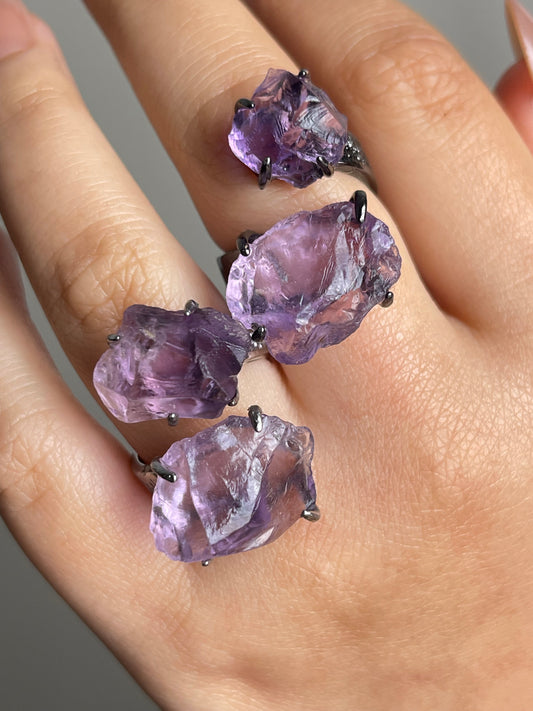 Close-up of raw amethyst ring showing natural crystal texture on hand
