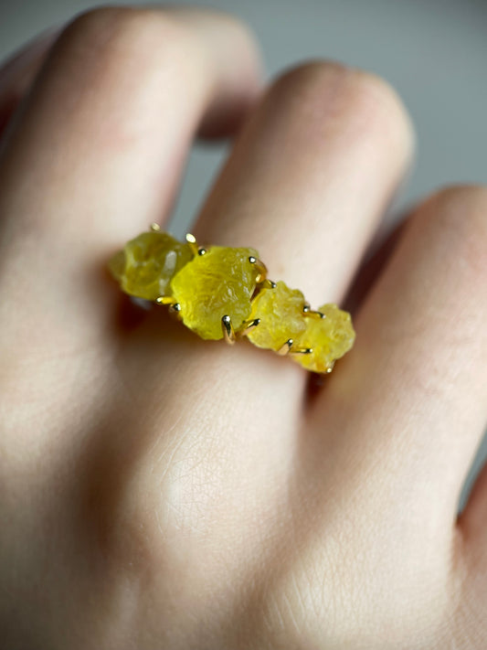 raw brucite crystal ring close up on hand yellow mineral