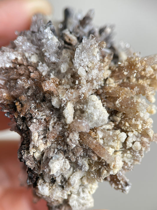 Close-up of cream and translucent Creedite crystal clusters on natural matrix