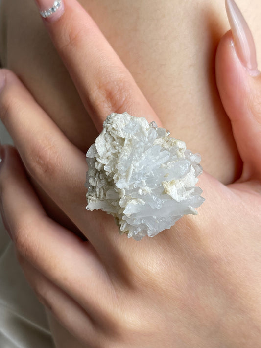 Raw creedite crystal cluster ring worn on hand close-up