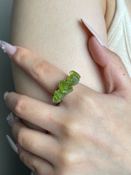 close up look raw peridot crystal ring