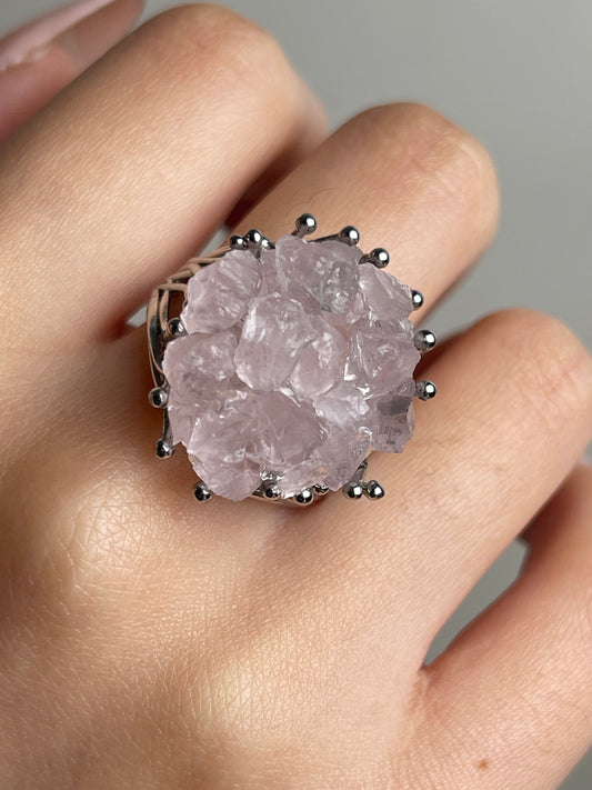 Close-up of rose quartz bouquet ring with hand-assembled raw crystals worn on hand