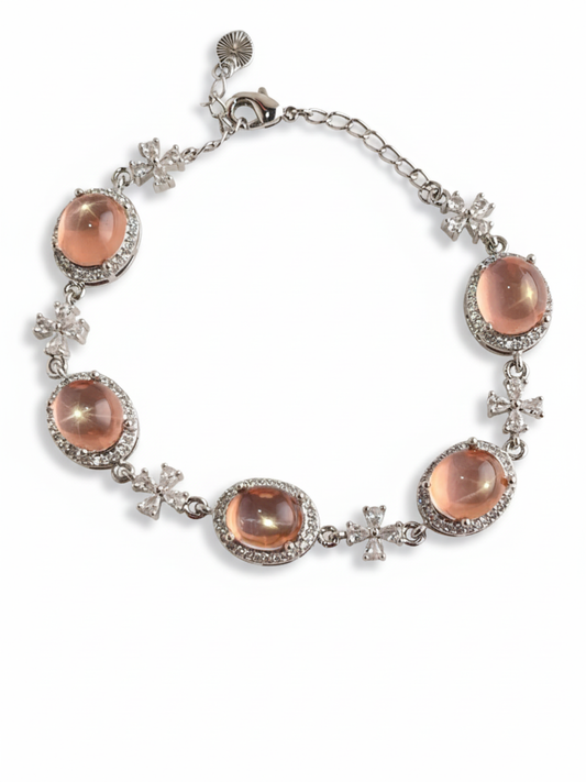 Bracelet with pink rose quartz and silver accents on a white background