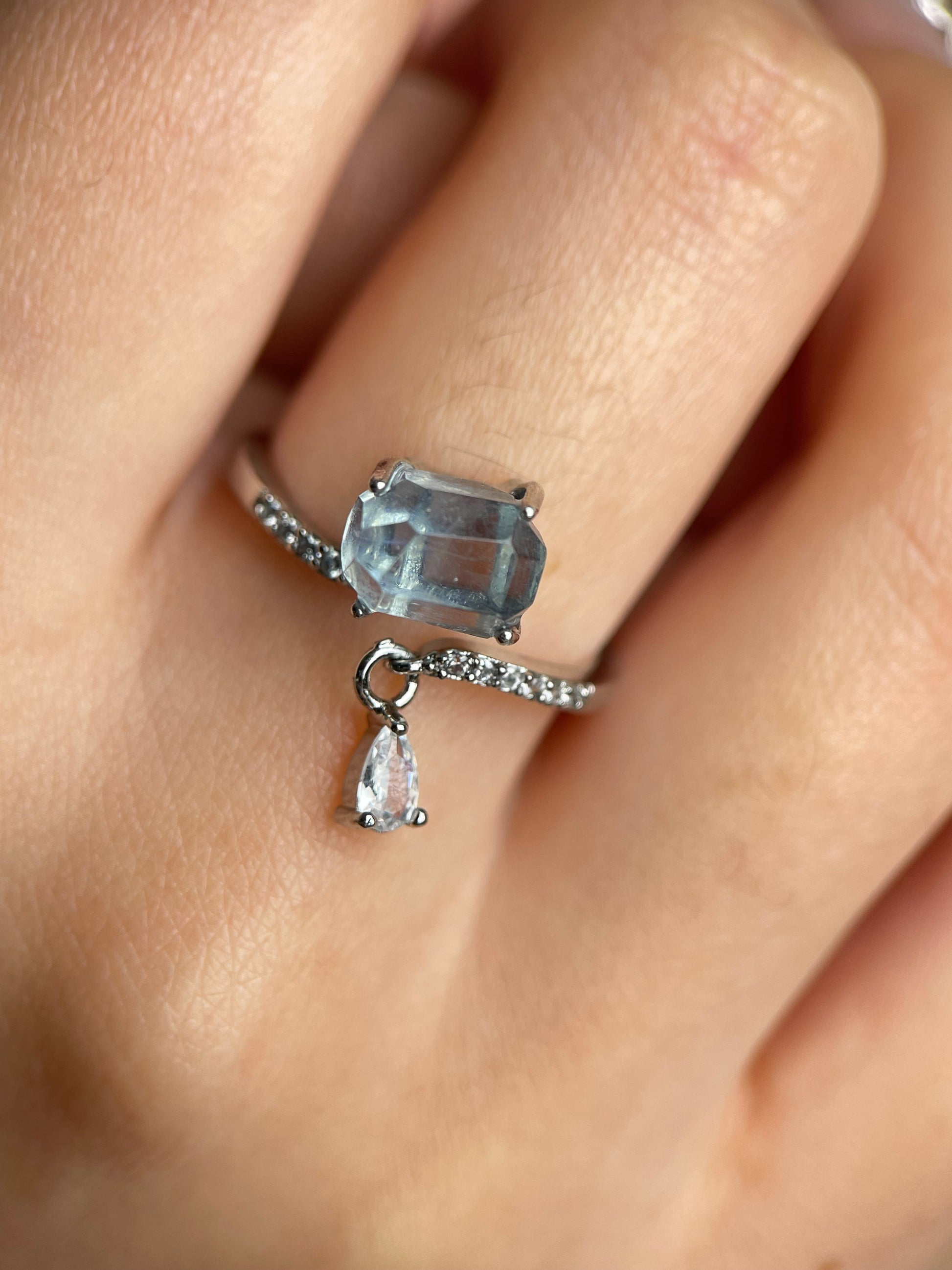 Close-up of aquamarine ring on hand with natural freeform cut