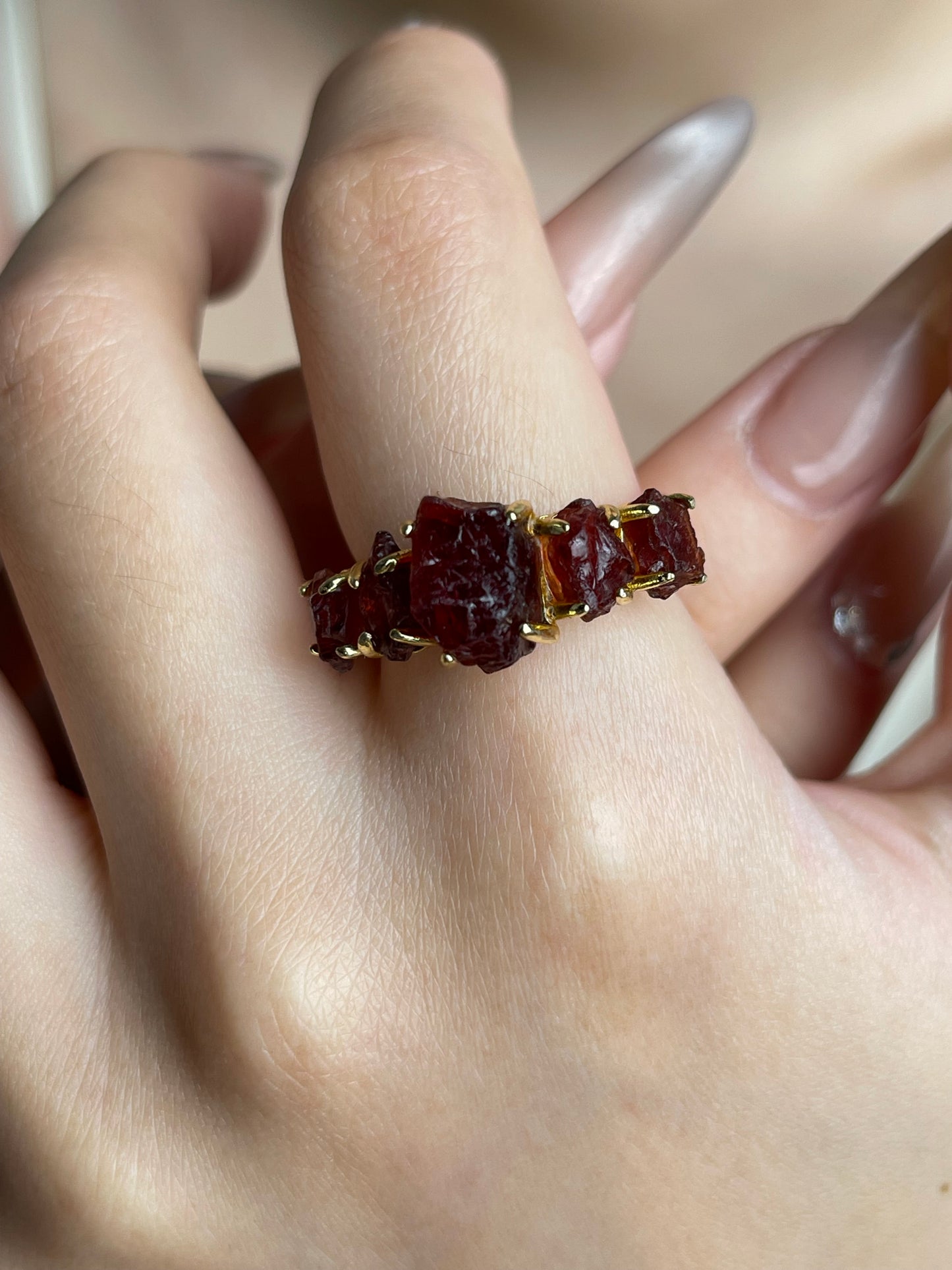Raw garnet ring worn close up detail