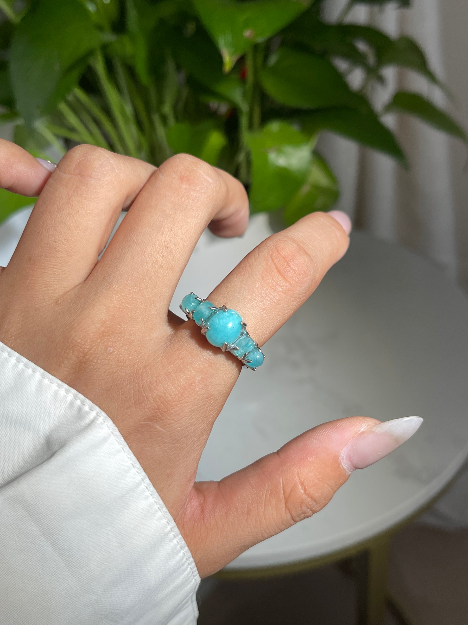 Close-up hand shot of amazonite band ring showing soft blue green feldspar stones