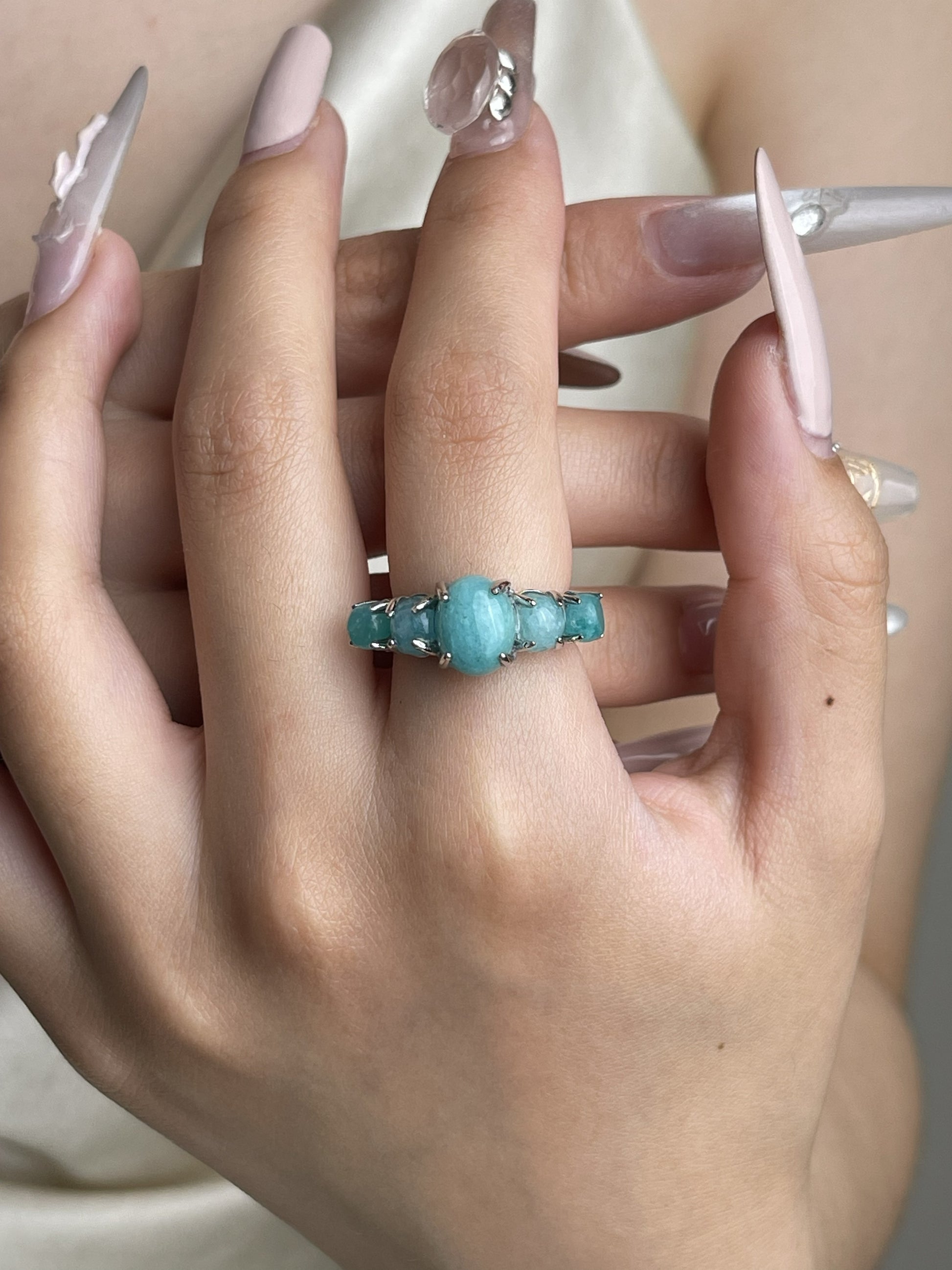 Amazonite band ring worn on hand with soft blue green polished stones