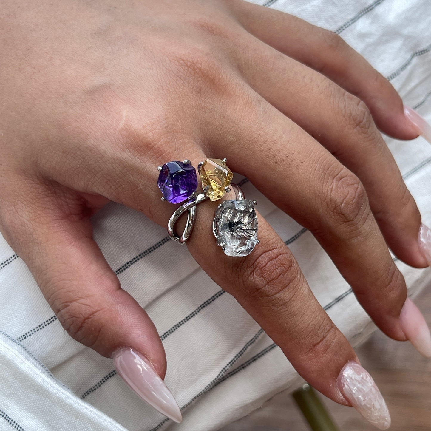 Close up of amethyst, citrine and black tourmalinated quartz freeform ring worn on hand
