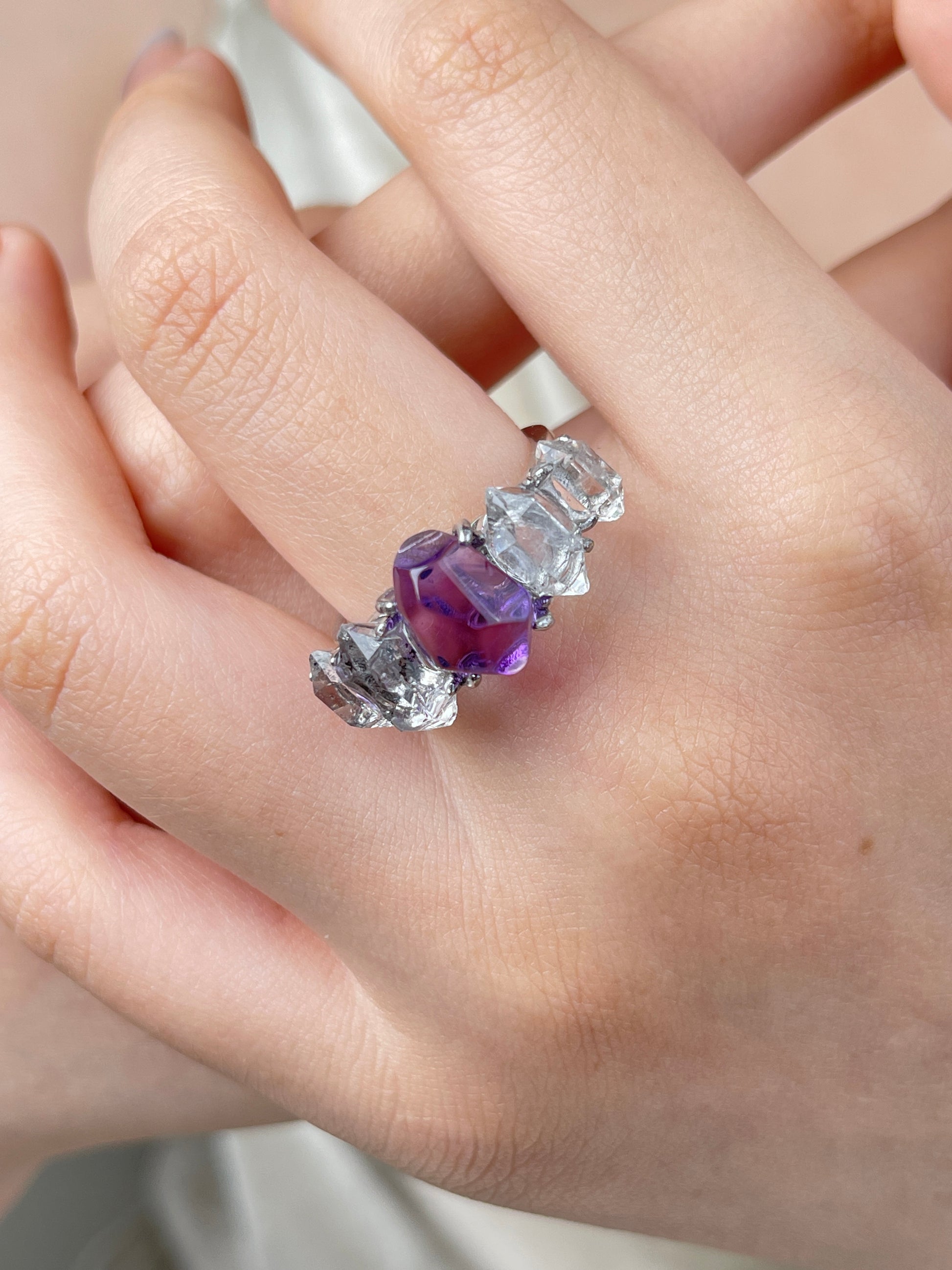Amethyst and Herkimer Diamond Quartz ring on hand with rich purple freeform amethyst and bright clear crystals