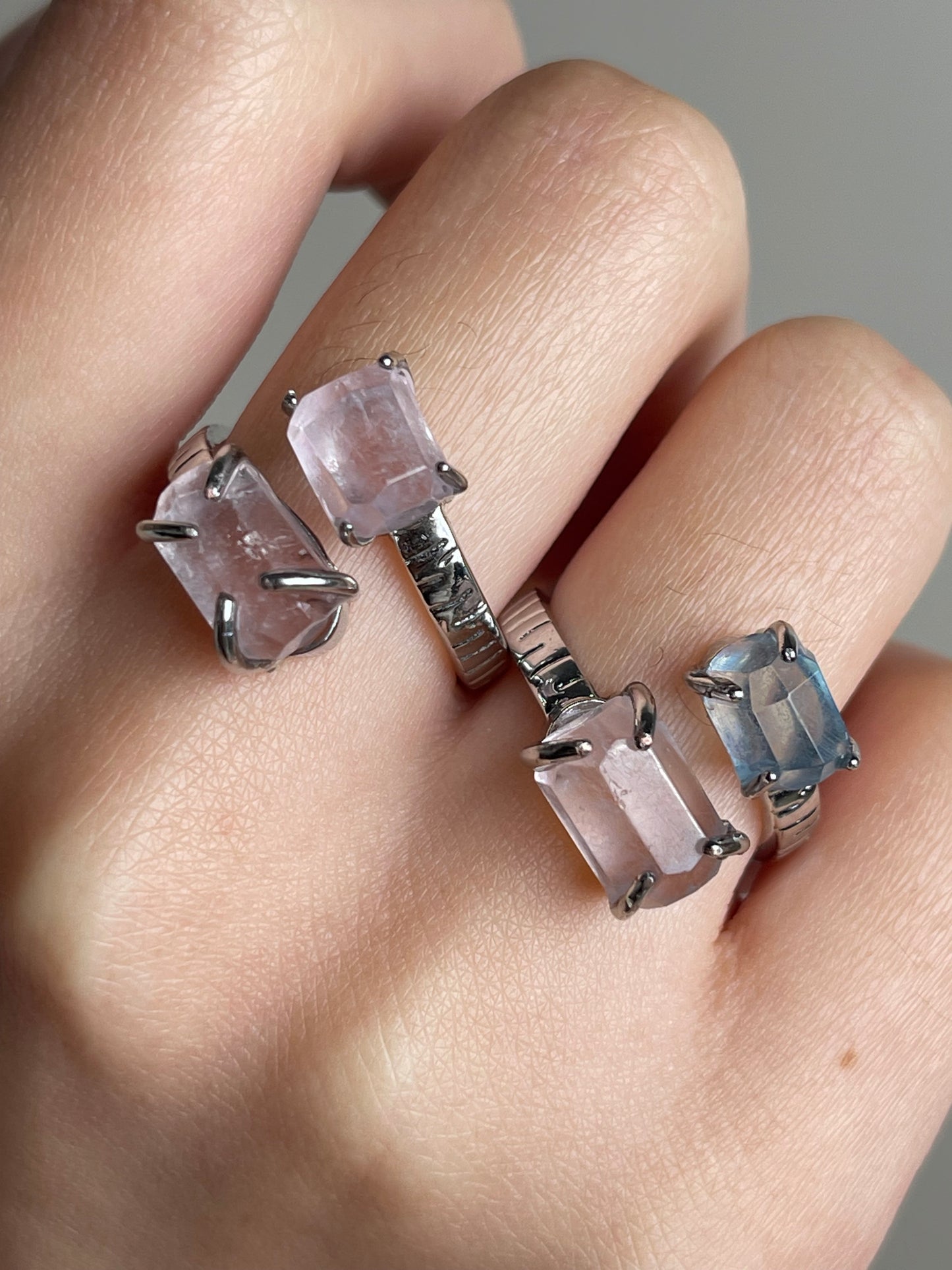 Close-up hand shot of Aquamarine and Morganite twin stone ring showing hand-cut natural crystals