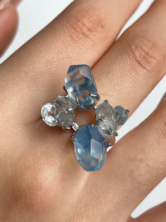 Close-up of aquamarine ring worn on hand with blue topaz and Hakima Diamond quartz natural crystal jewelry