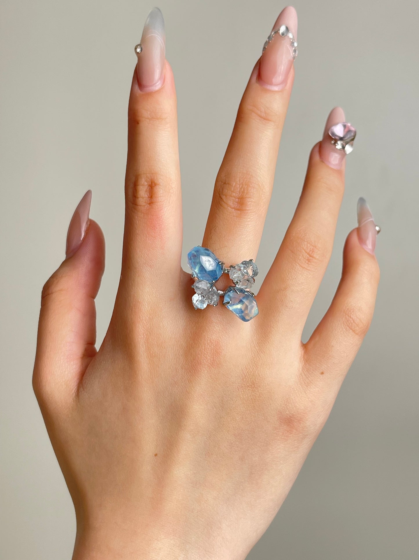 Aquamarine ring worn on hand with blue topaz and Hakima Diamond quartz natural crystal jewelry