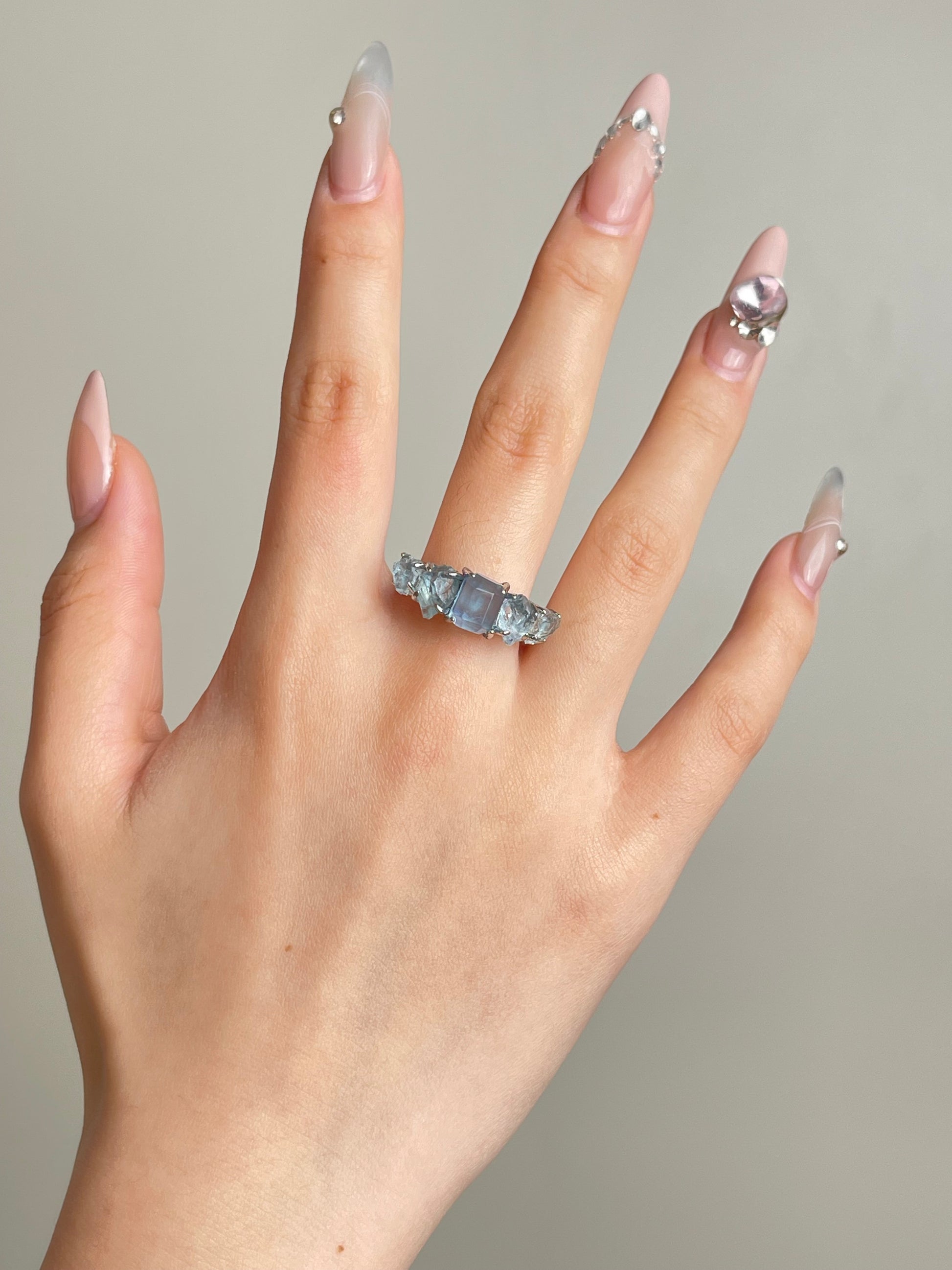 Aquamarine row ring worn on hand with natural raw and hand cut aquamarine from Brazil