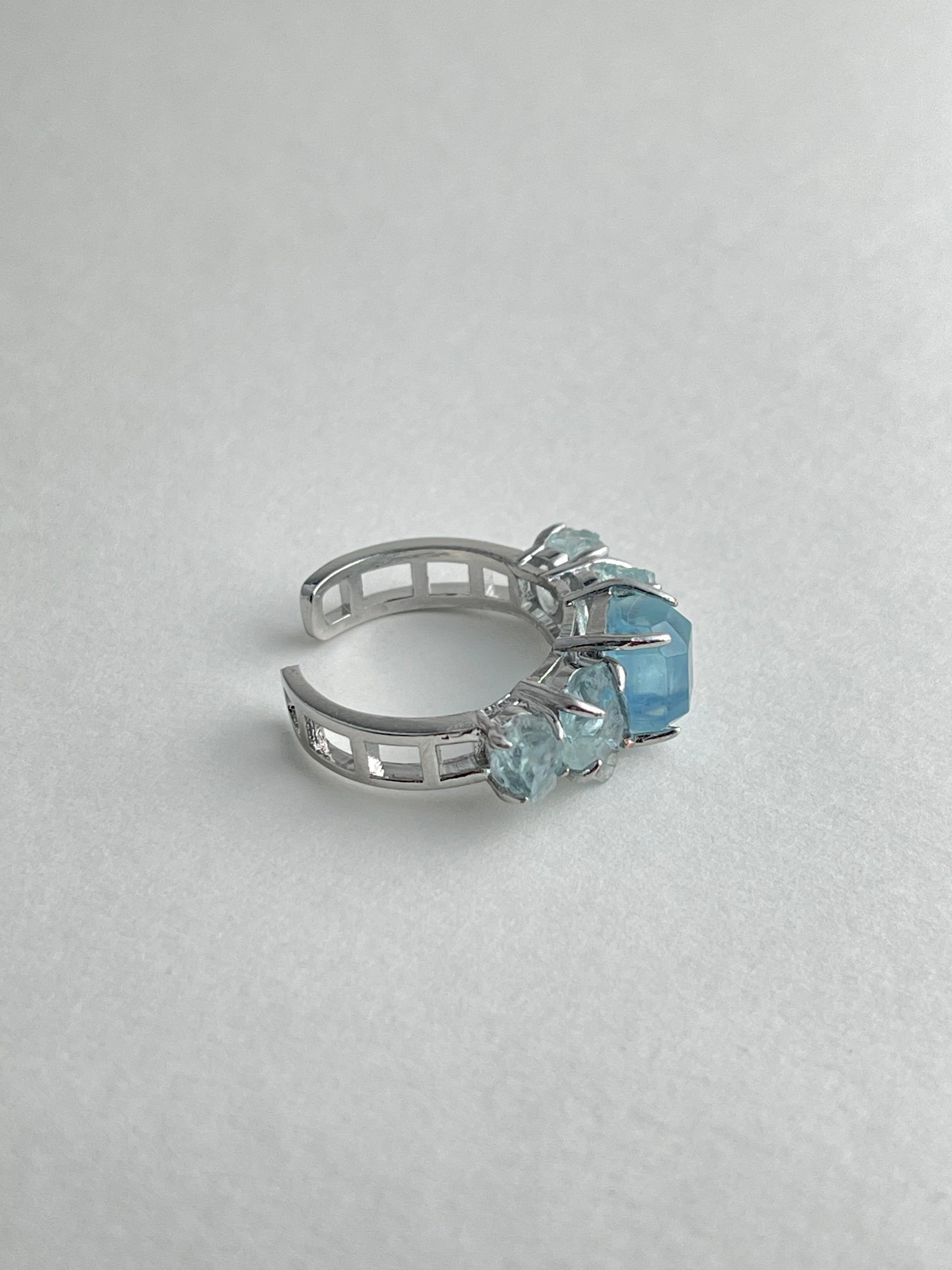 Side view of aquamarine row ring showing hand cut and raw aquamarine crystal structure