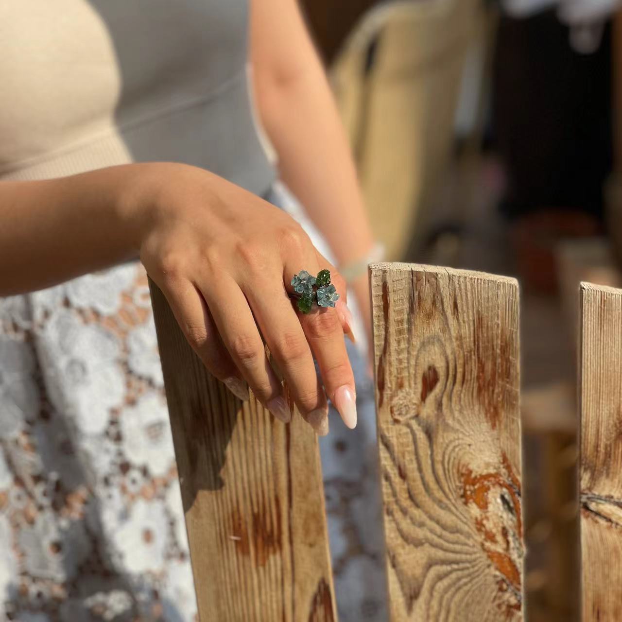 Close-up hand view of Blue Apatite flower ring with Chalcopyrite and Chrome Diopside