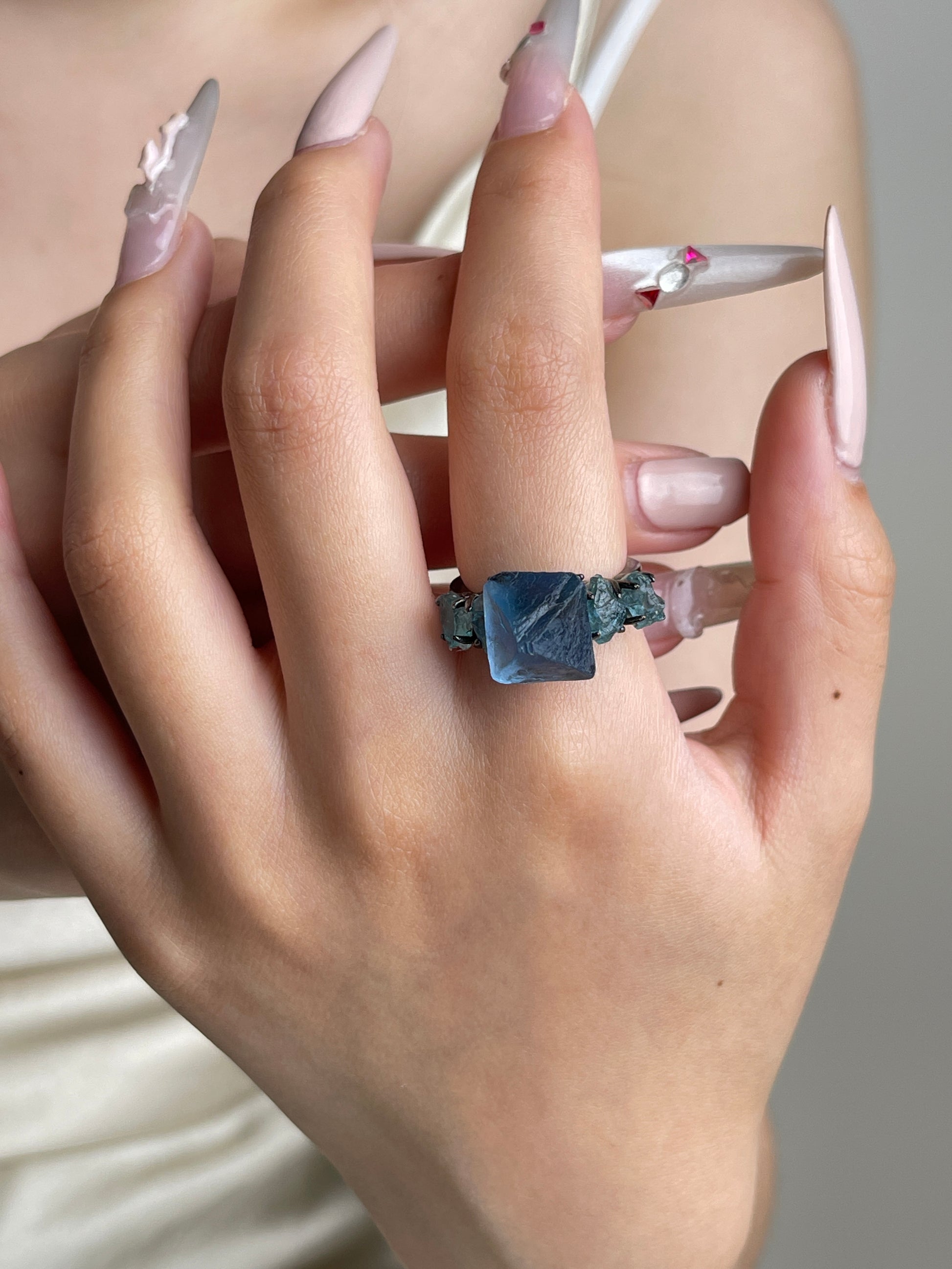 Blue octahedral fluorite and blue apatite ring worn on hand