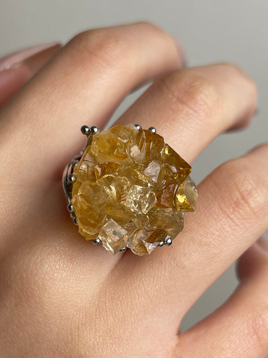 Close-up of citrine bouquet ring with hand-assembled raw crystals worn on hand