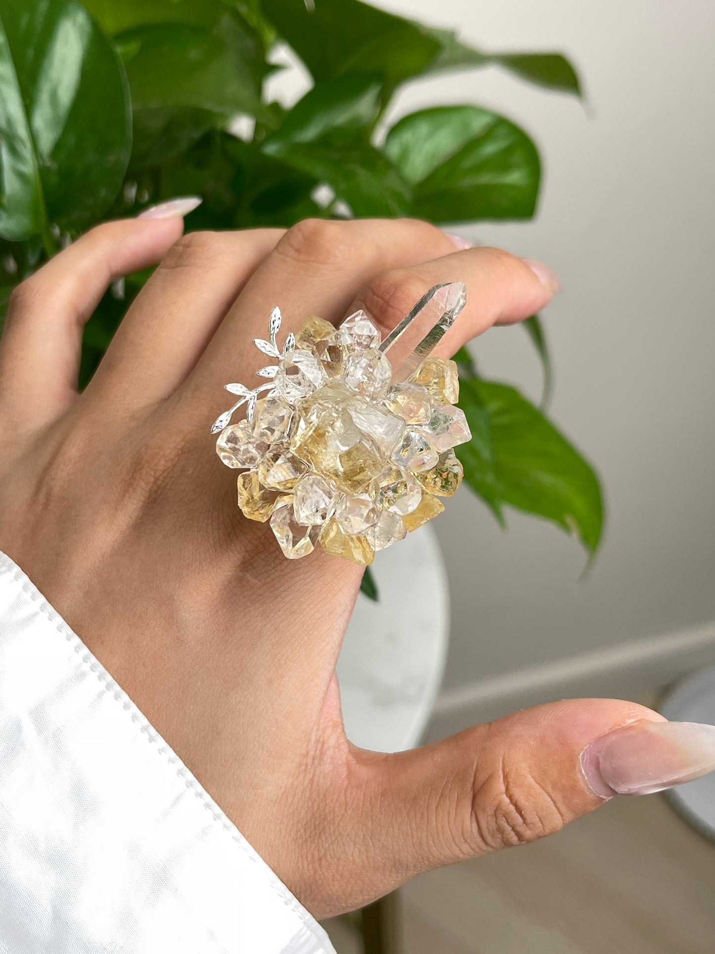 Close up of citrine Herkimer Diamond Quartz and Lemurian seed quartz flower ring worn on hand