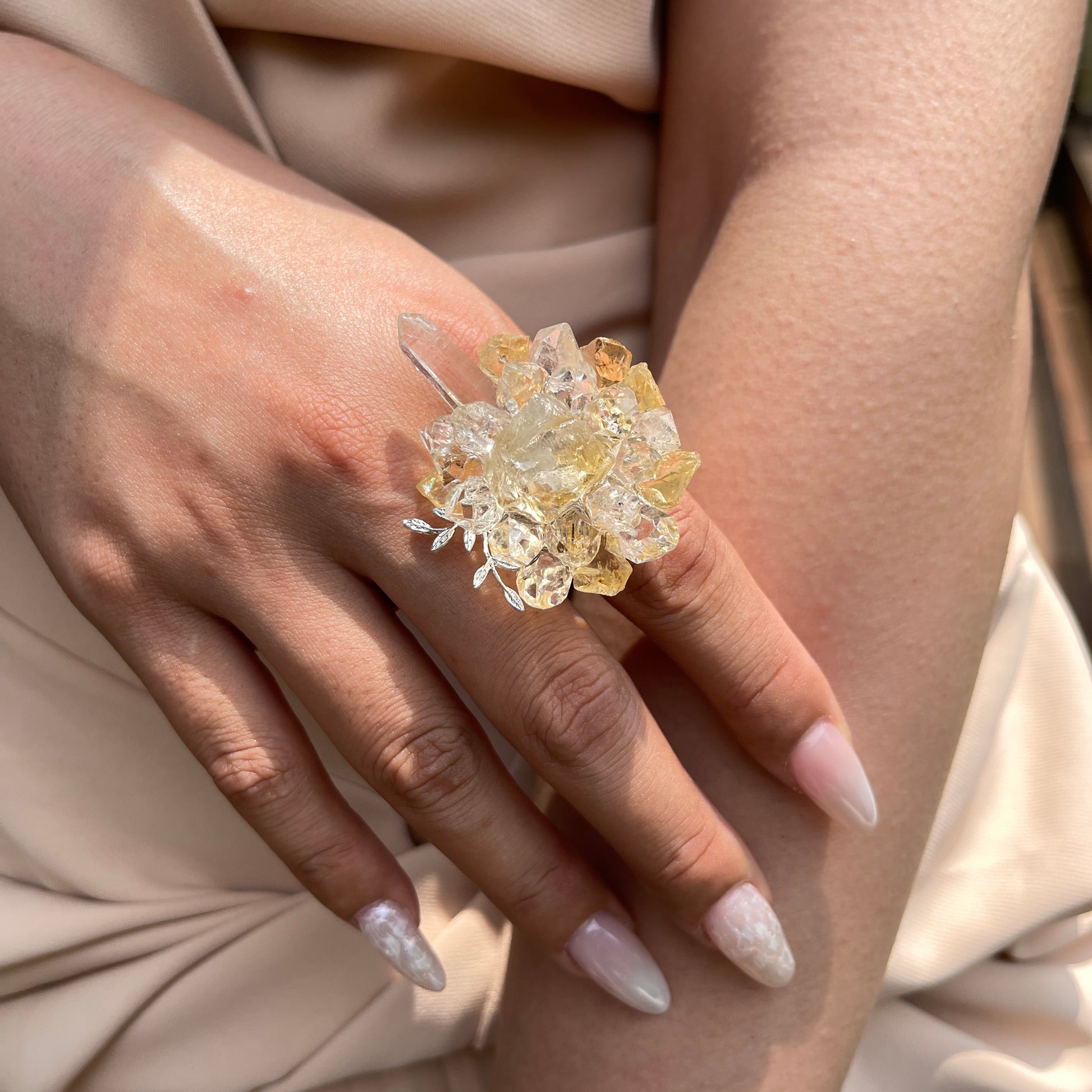 Close up of citrine Herkimer Diamond Quartz and Lemurian seed quartz flower ring worn on hand