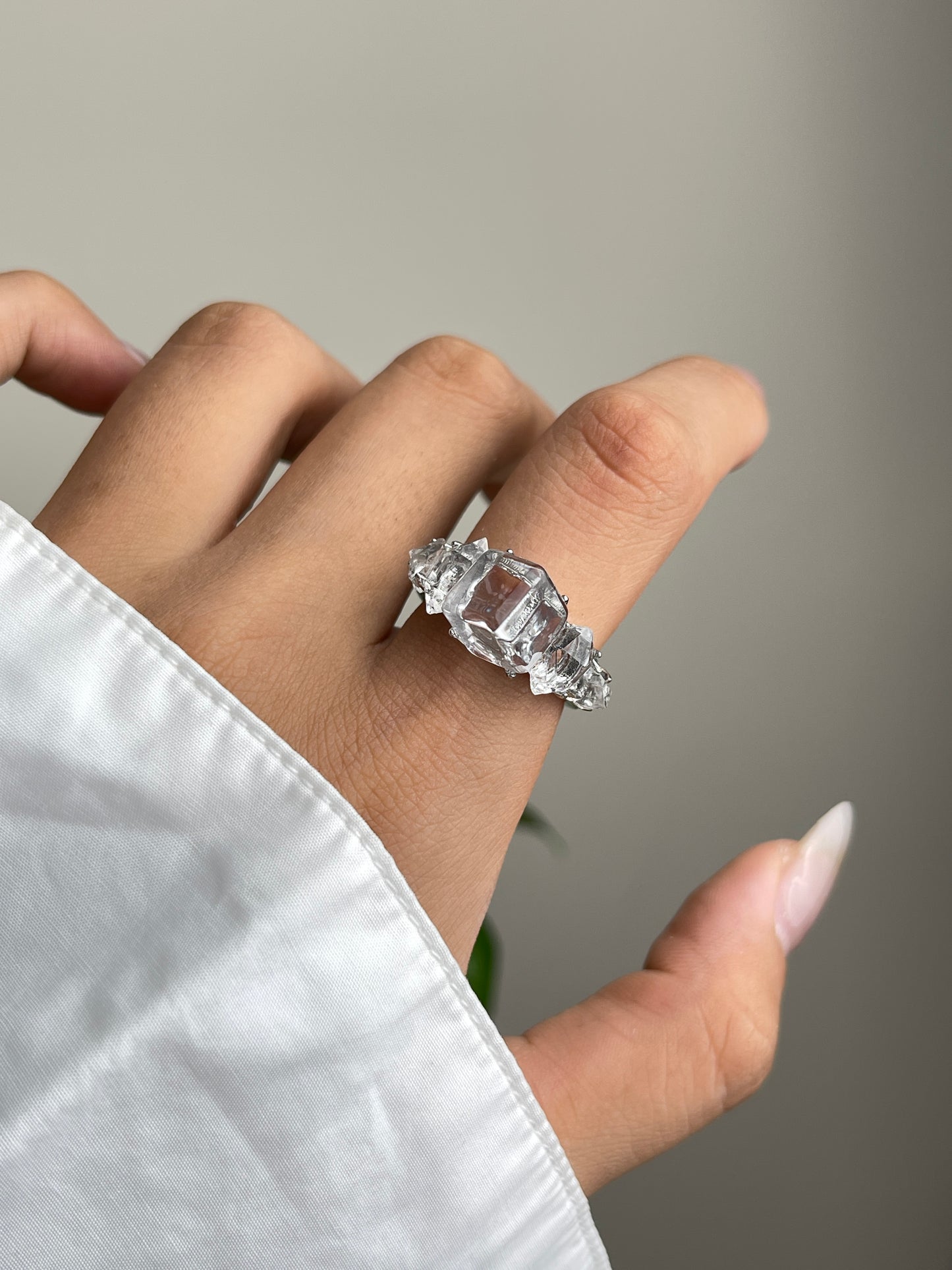 Close-up hand view of Clear Quartz cube ring with Herkimer Diamond Quartz side stones