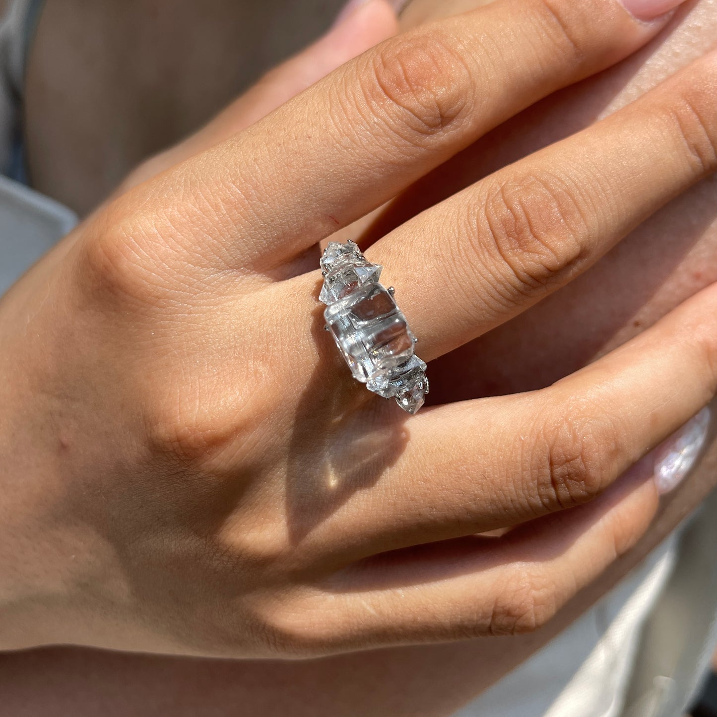 Close-up hand view of Clear Quartz cube ring with Herkimer Diamond Quartz side stones