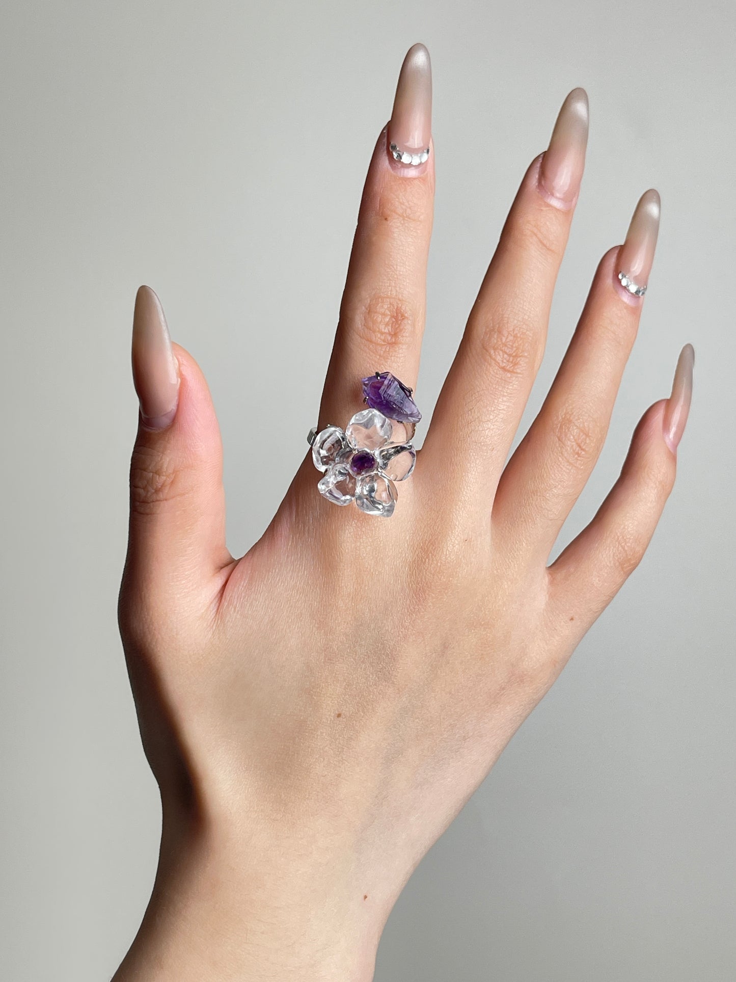 Hand view of Clear Quartz Flower Ring with raw Amethyst