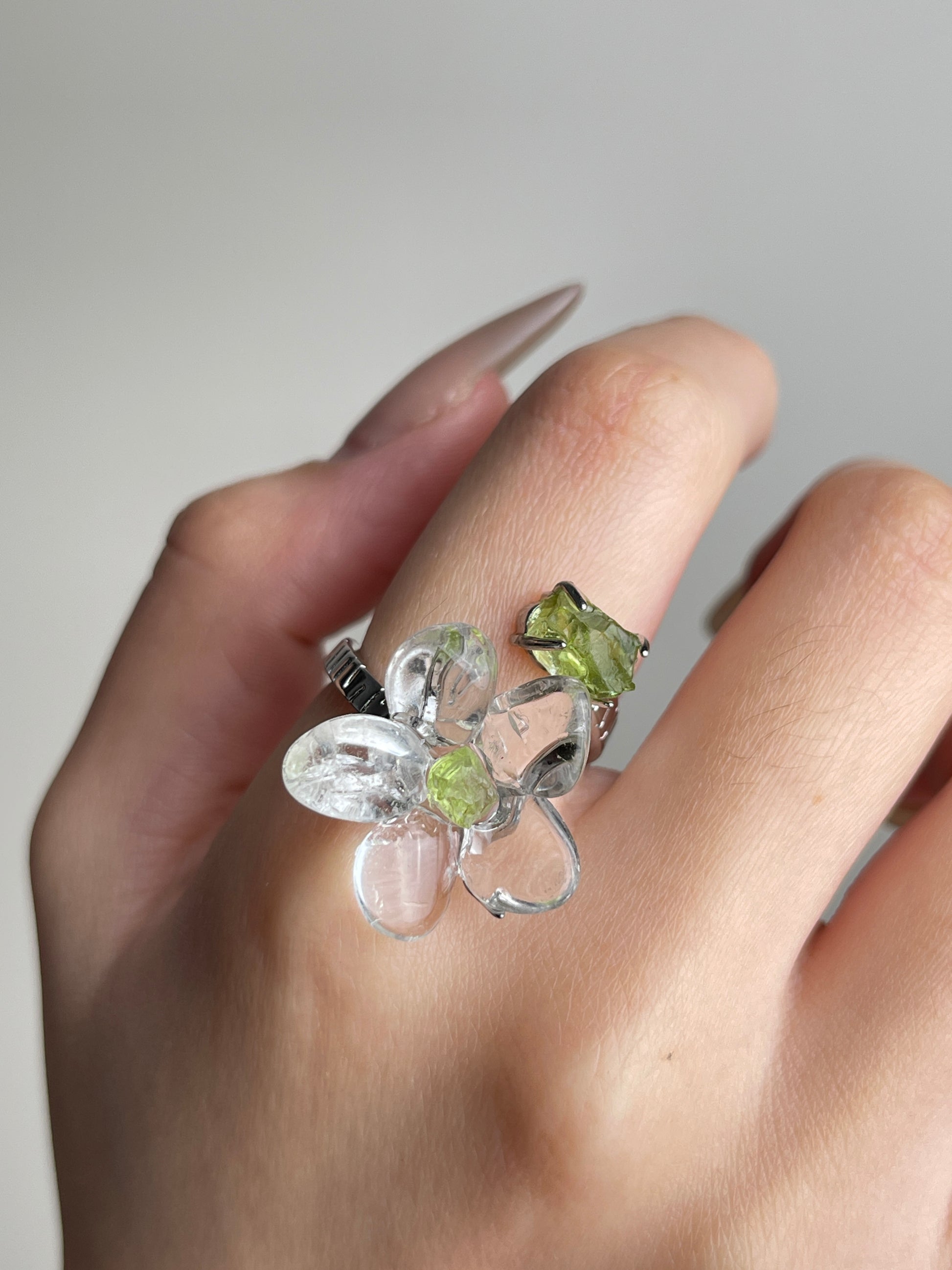 Close-up hand view of Clear Quartz Flower Ring with raw Peridot