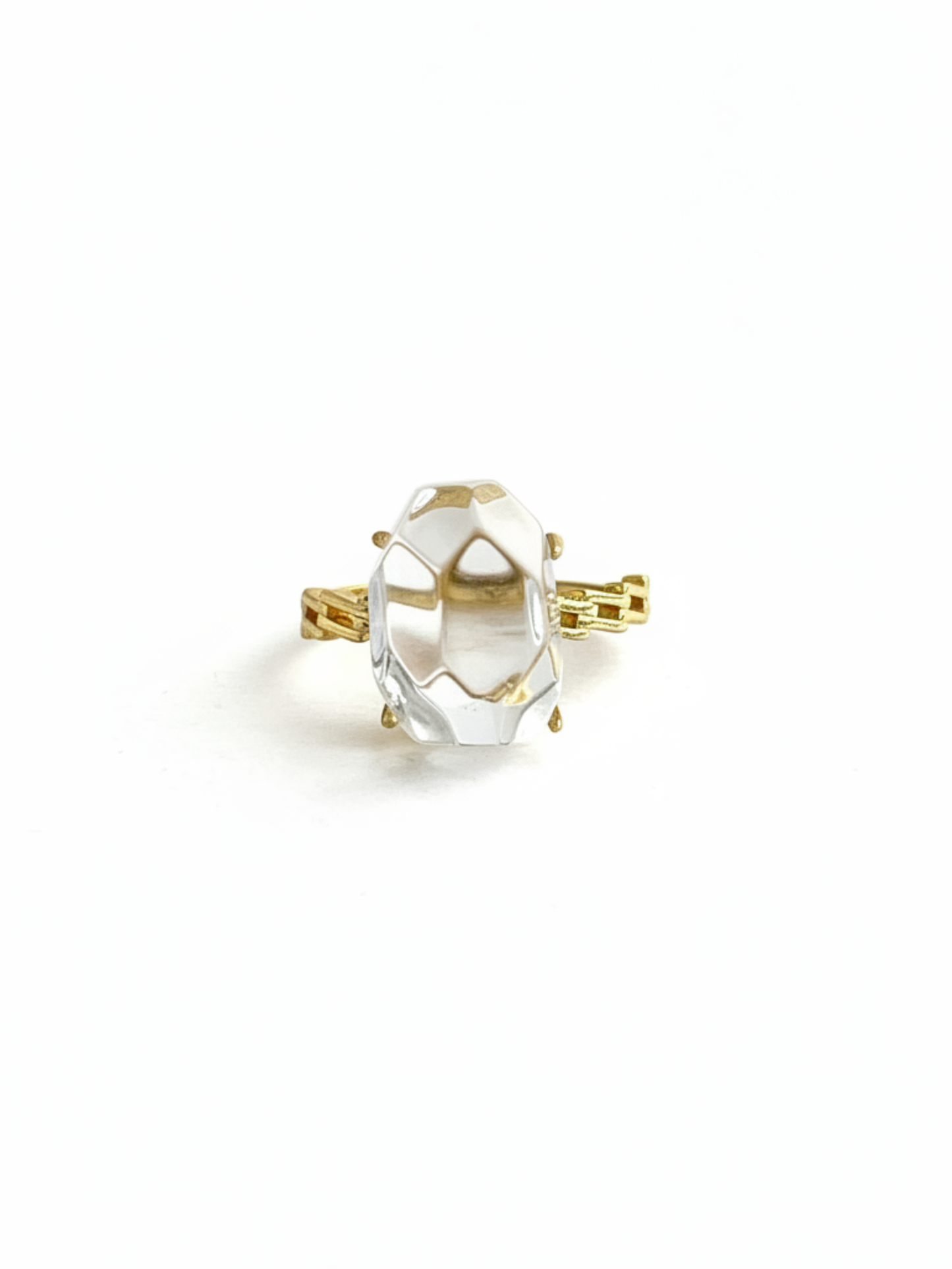 Front view of a Clear Quartz freeform ring with a faceted transparent crystal centerpiece and gold tone band
