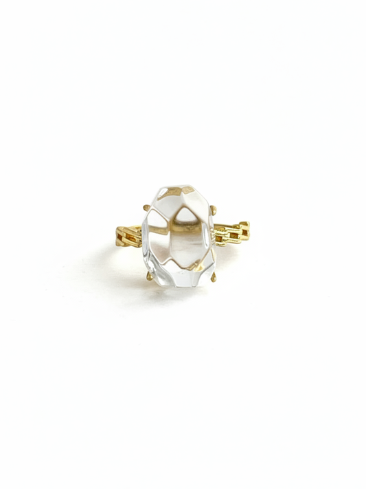 Front view of a Clear Quartz freeform ring with a faceted transparent crystal centerpiece and gold tone band