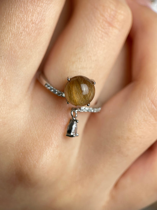 Close-up of copper rutilated quartz ring with fine needle-like inclusions