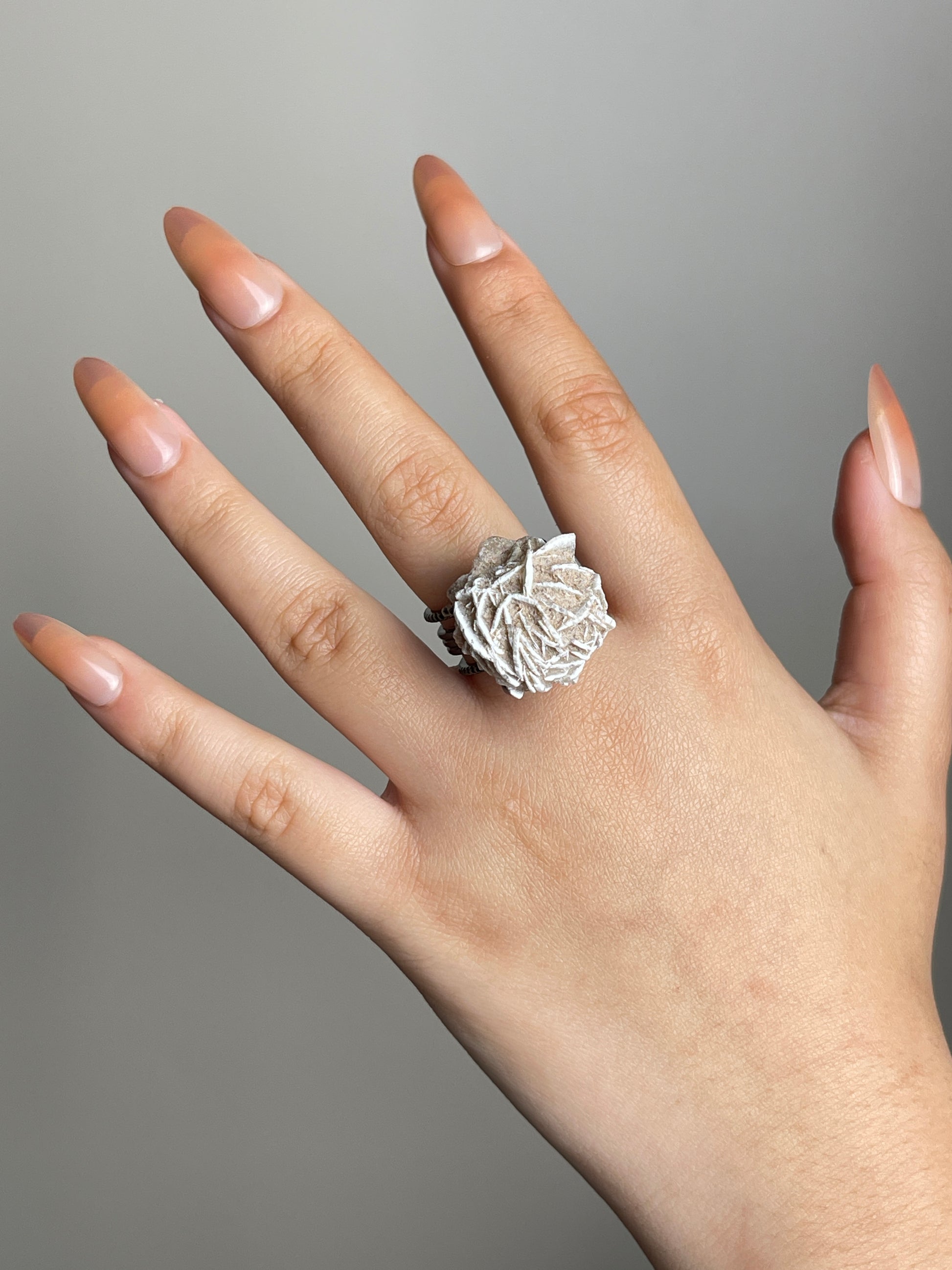 Hand shot of Desert Rose mineral specimen ring from Morocco in natural light.