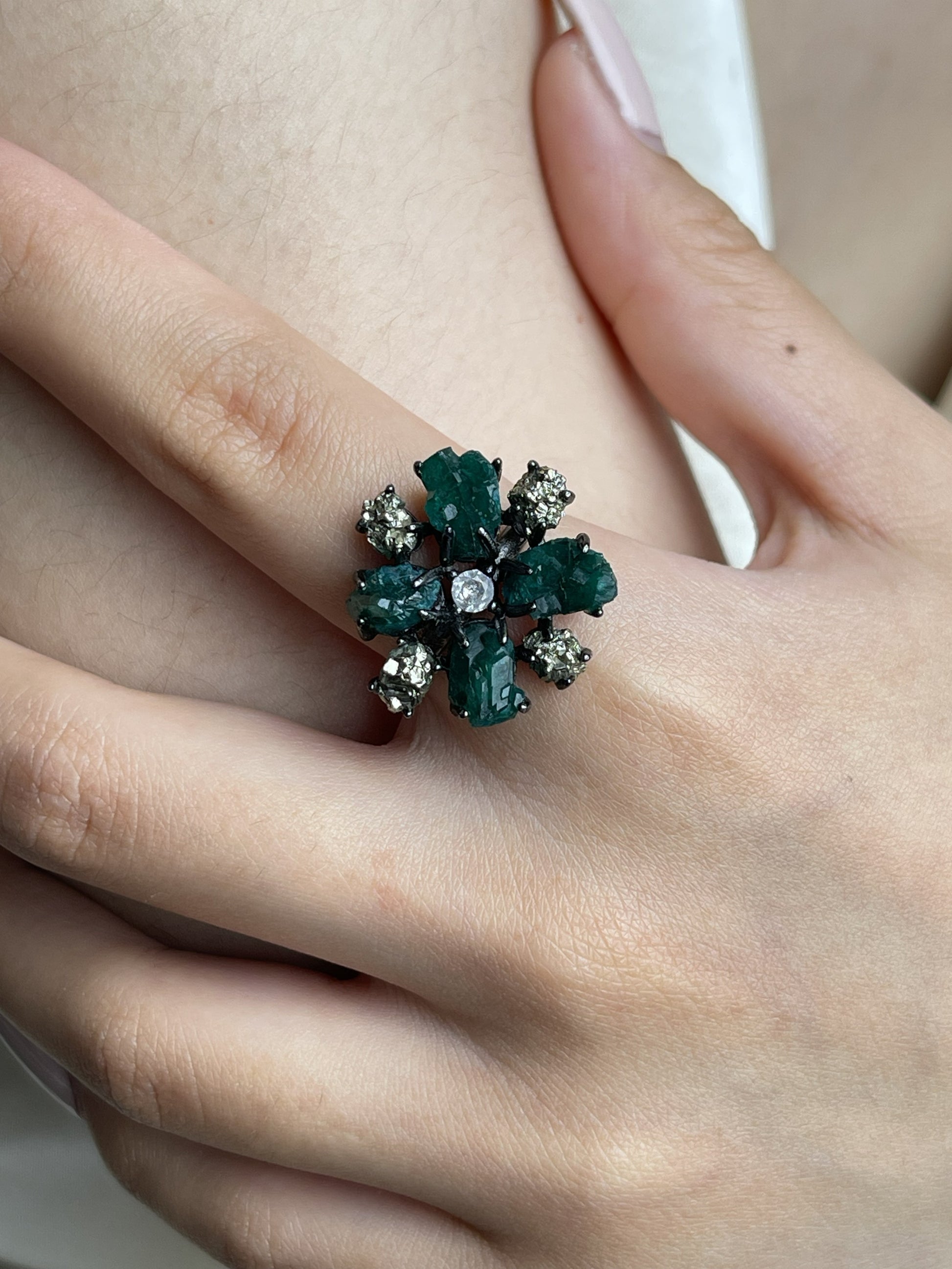 Close-up hand view of raw Dioptase and Chalcopyrite snowflake mineral specimen ring