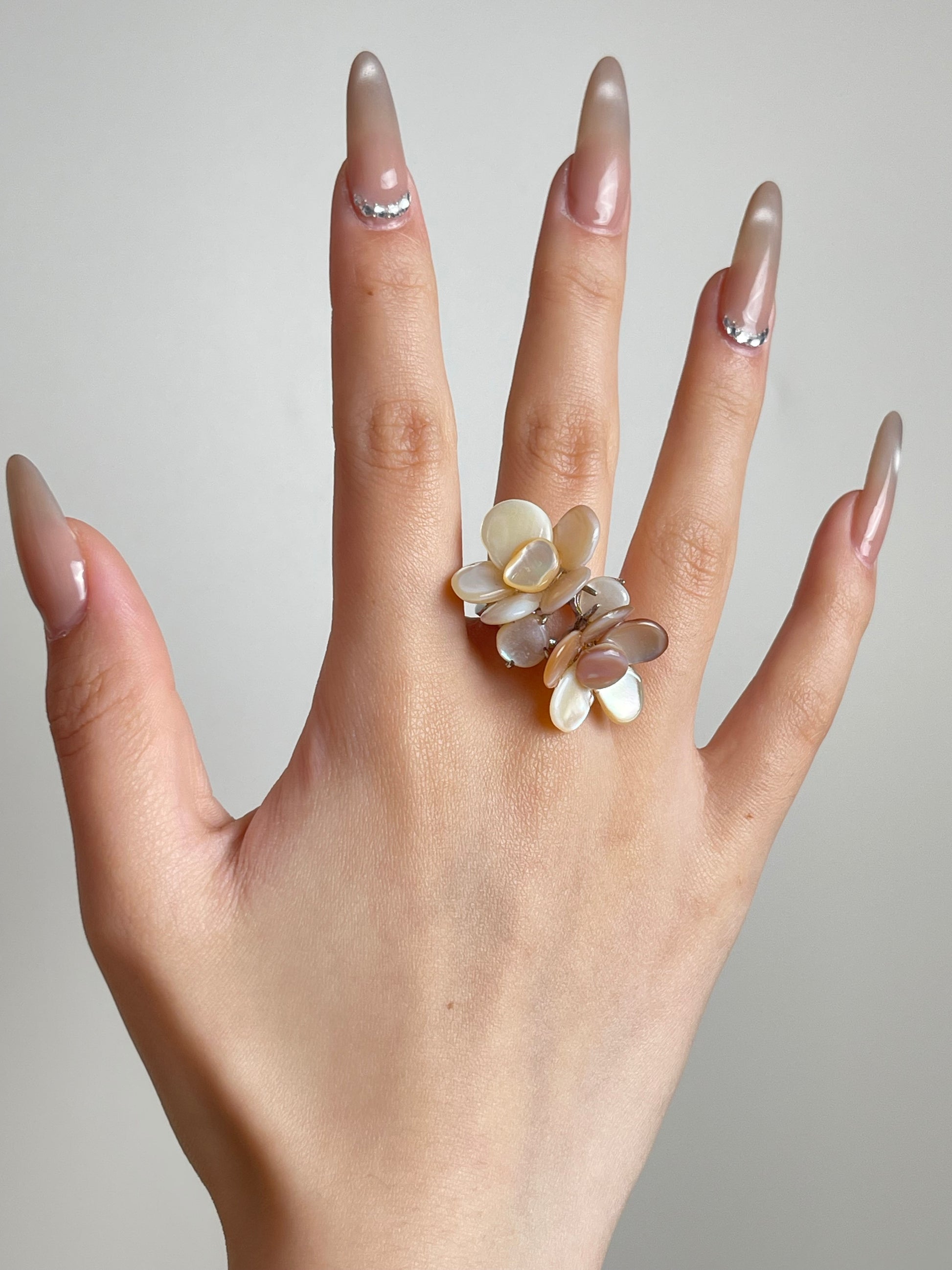 Hand shot of double Mother of Pearl flower ring by Oryssia