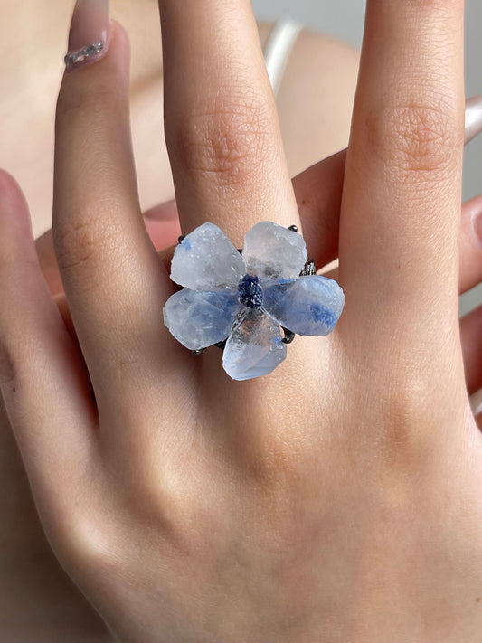 Close-up hand shot of dumortierite quartz flower ring with tanzanite fluorite