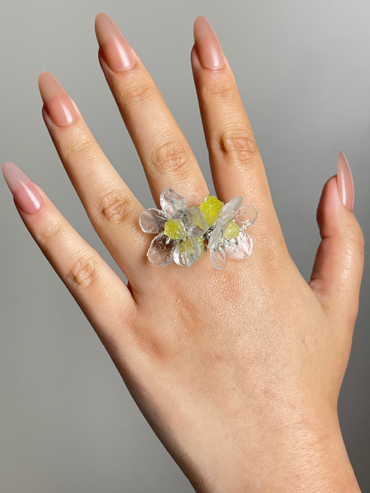 Quartz and brucite flower ring worn on hand in silver finish