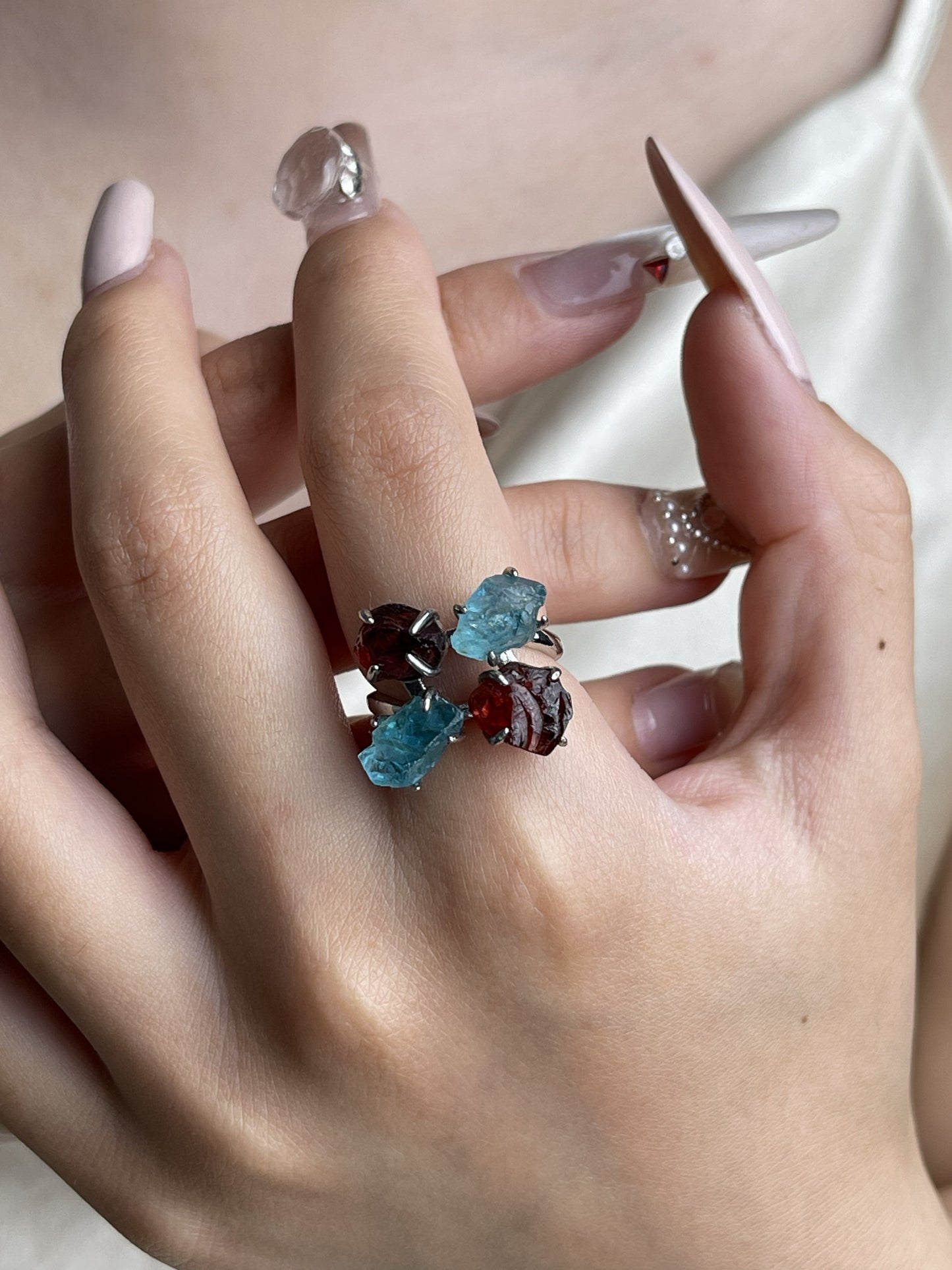 Raw Garnet and Blue Apatite crystal ring worn on hand