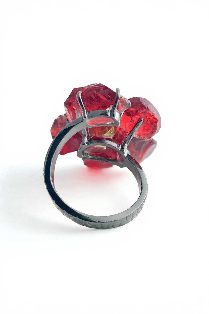 Back view of garnet flower ring with peridot center and open band design