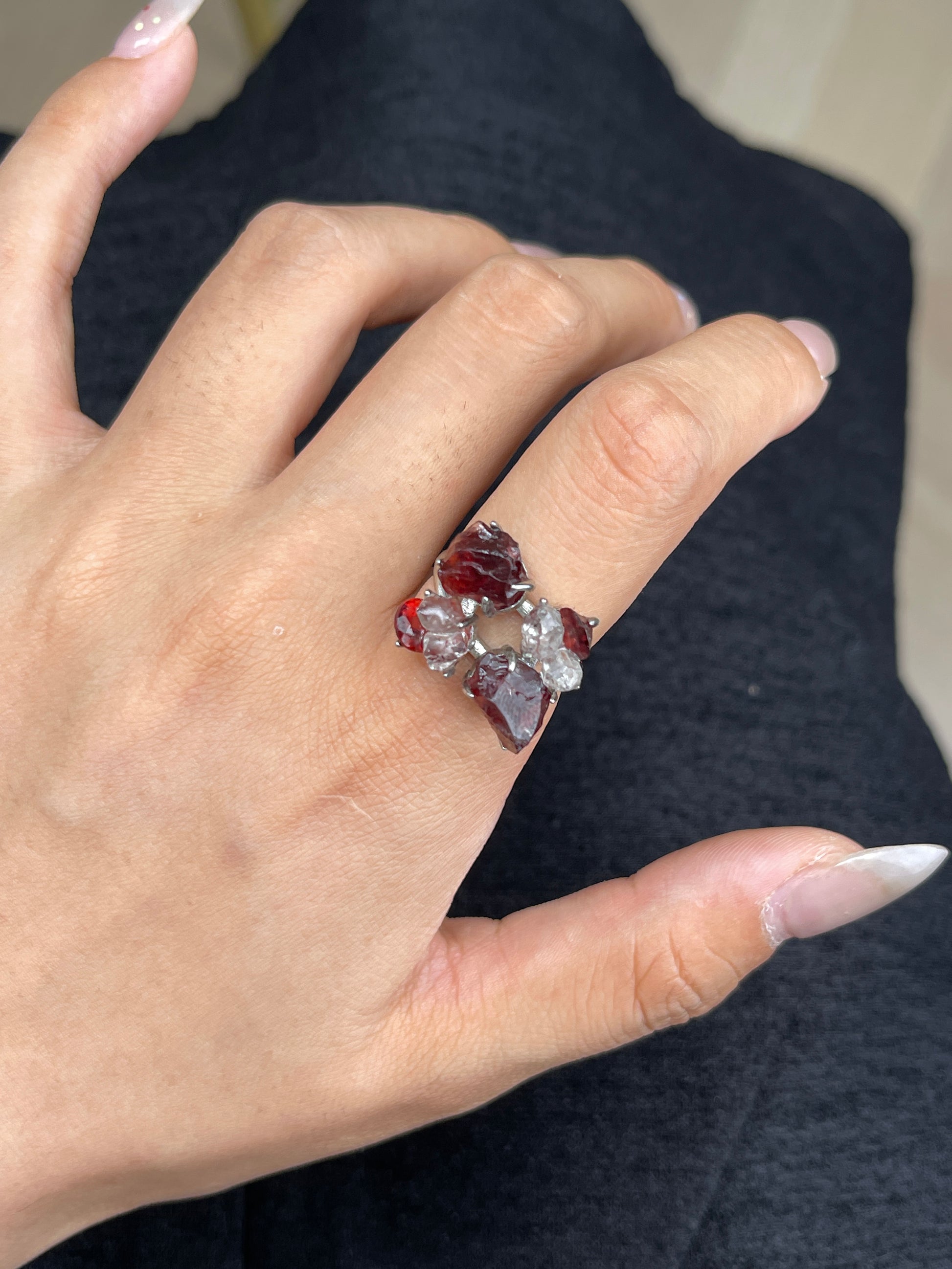 Close up of garnet ring worn on hand with raw garnet cut garnet and Hakima Diamond Quartz