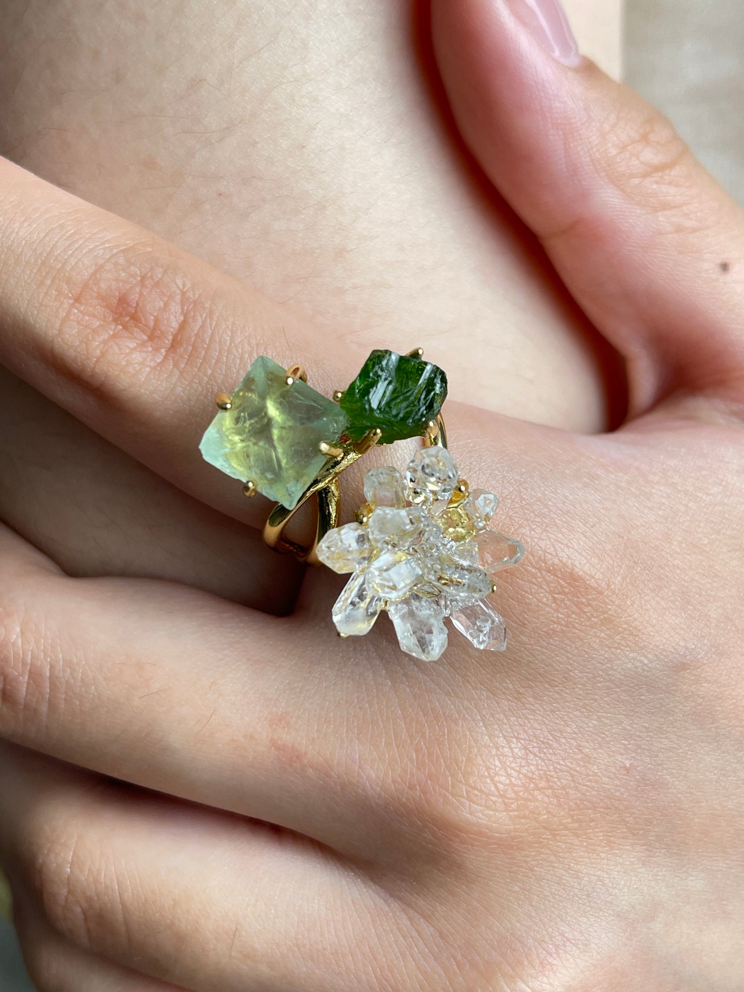 Close up of green octahedral fluorite, chrome diopside and Herkimer Diamond Quartz flower ring worn on hand