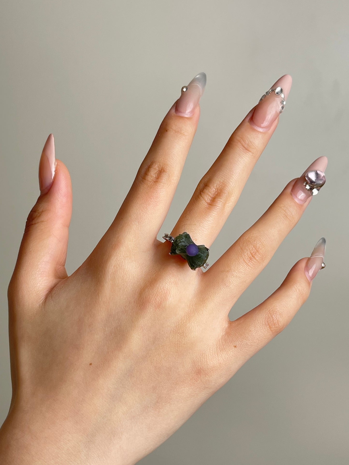 Green prehnite and purple grape agate ring worn on hand